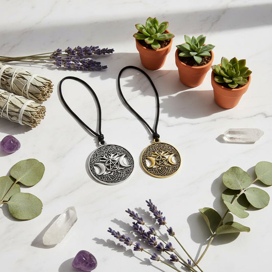 Two silver and gold pendants with Celtic designs and moon phases on a dark background.