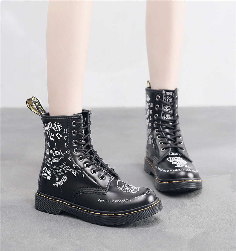 Black leather boots with white text design on a gray background