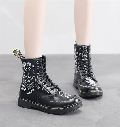 Black leather boots with white text design on a gray background