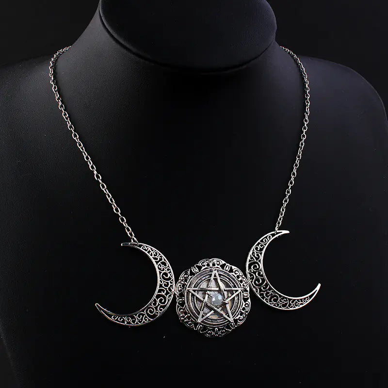 Necklace with triple moon pendant and pentacle design on a black mannequin.
