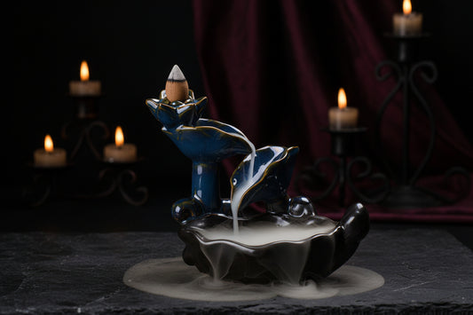 Ceramic incense burner with blue and gold design on a textured surface