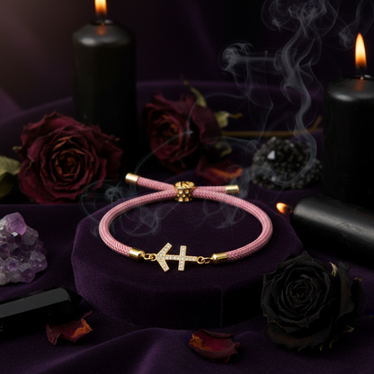 Pink bracelet with gold anchor charm on a white background