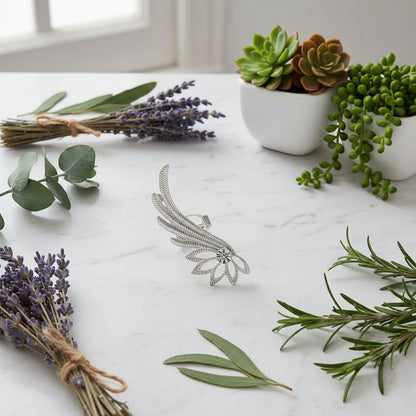 Silver feather-shaped earring worn by a person with dark hair.