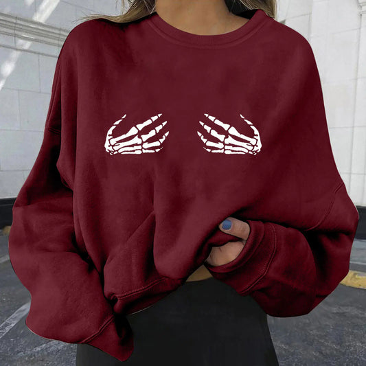 Maroon sweatshirt with skeleton hand design worn by a person.
