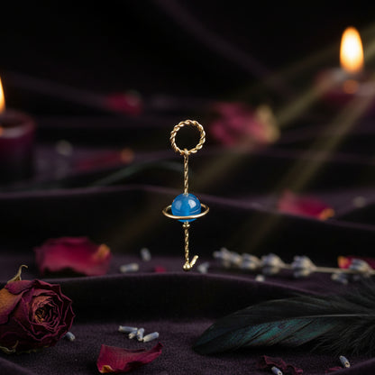 Gold ring with a blue gemstone on a white background