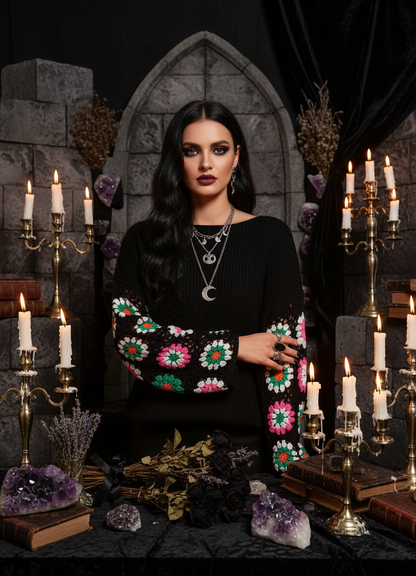 Woman wearing a black sweater with colorful floral patterns on the sleeves against a white background