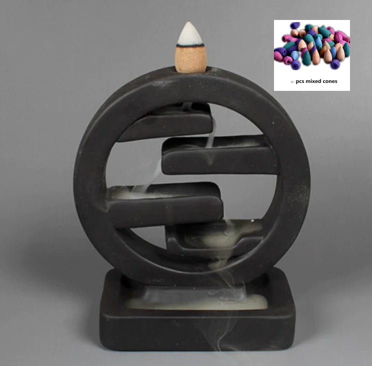 Black circular incense burner with a single incense cone on a gray background, inset with colorful incense cones.