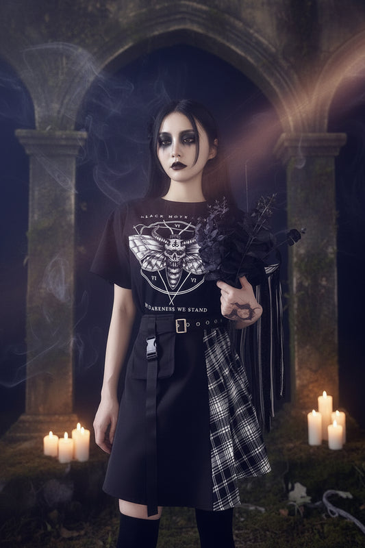 Person wearing a black t-shirt with a graphic design, holding dark flowers against a plain background