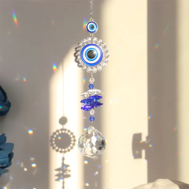 Decorative hanging ornament with blue evil eye design and crystal elements on a neutral background