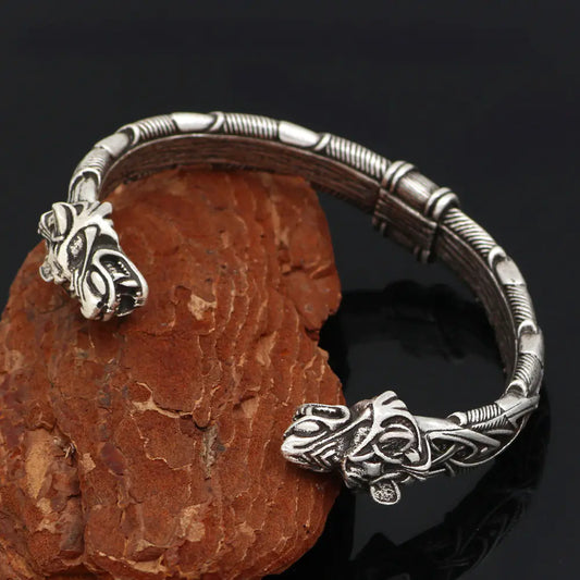 Silver bracelet with intricate designs on a dark background