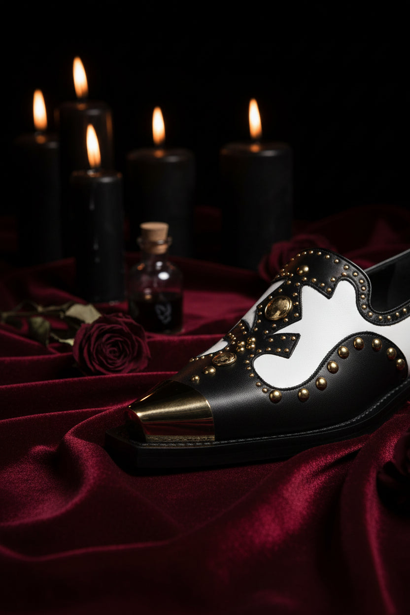 Black shoe with gold accents on a white background