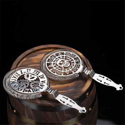 Two silver bar tools on a wooden barrel against a dark background