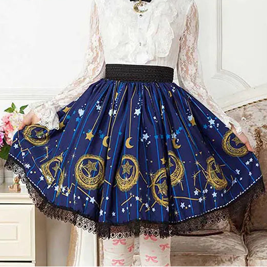 Person wearing a white lace top and blue skirt with star and moon patterns, sitting on a couch.