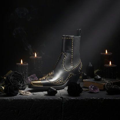 Black ankle boot with gold studs and gold tip on a white background