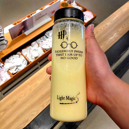 Hand holding a yellow water bottle with text and a logo, against a store background.