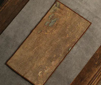 Brown doormat with floral pattern on a gray carpeted floor