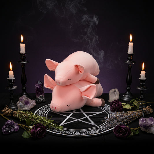 Two pink plush pigs stacked on top of each other with a white background