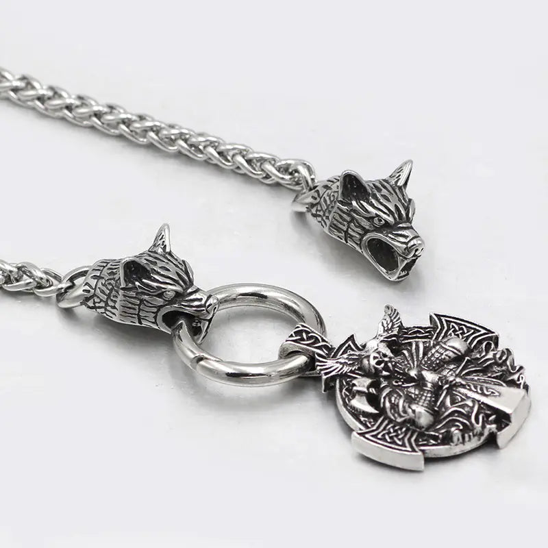 Silver necklace with wolf head pendants and a dragon emblem on a white background