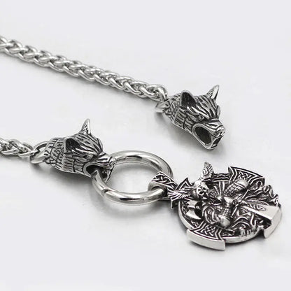 Silver necklace with wolf head pendants and a dragon emblem on a white background