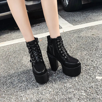 Black platform boots worn on a paved surface