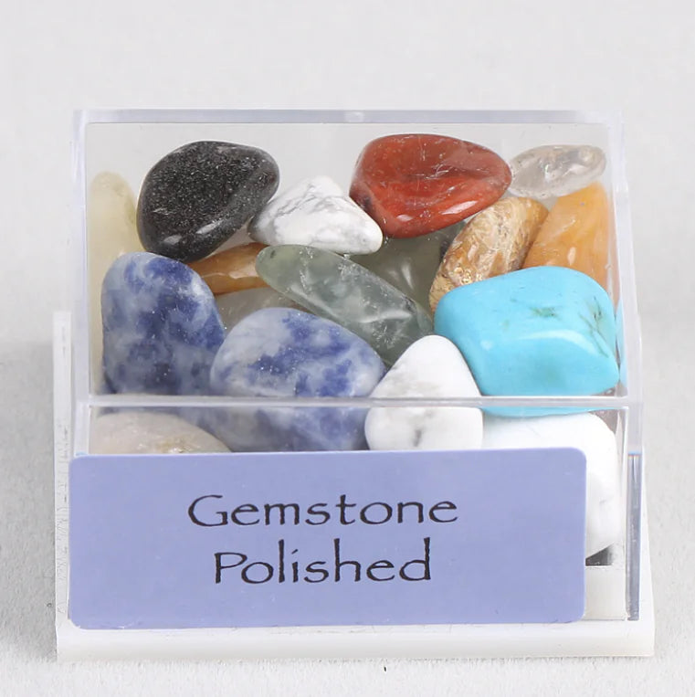 Box of polished gemstones with a label on a white background