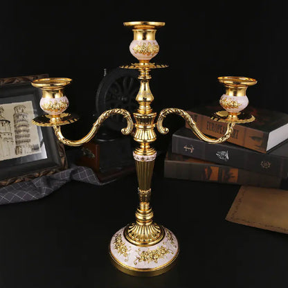 Gold candle holder with decorative design on a dark background