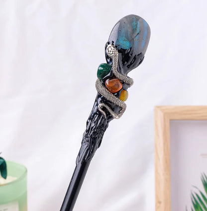Decorative crystal magic wand with gemstones on a white background