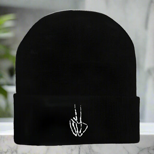 Black beanie with a white embroidered design on a white background