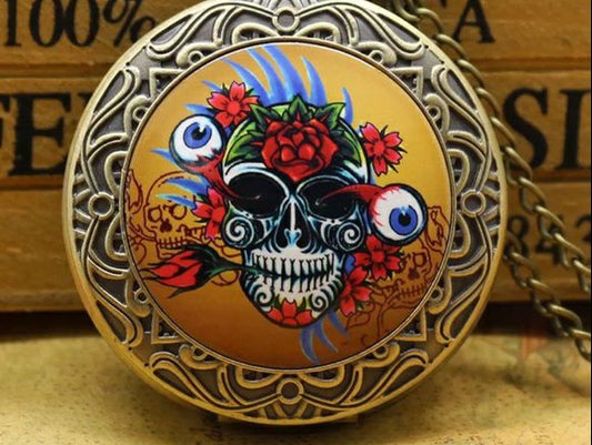Decorative pocket watch with skull and floral design on a wooden surface