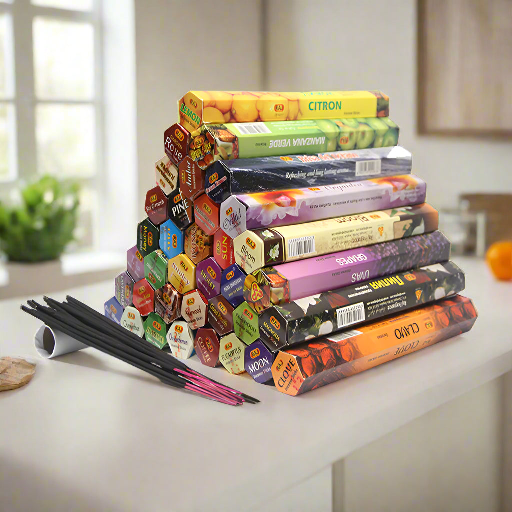 Stack of colorful incense boxes with incense sticks on a white background