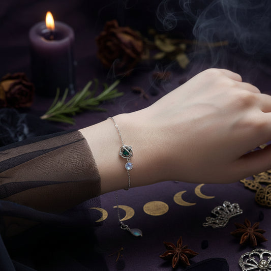 Silver bracelet with a green gemstone on a wrist against a soft, light background