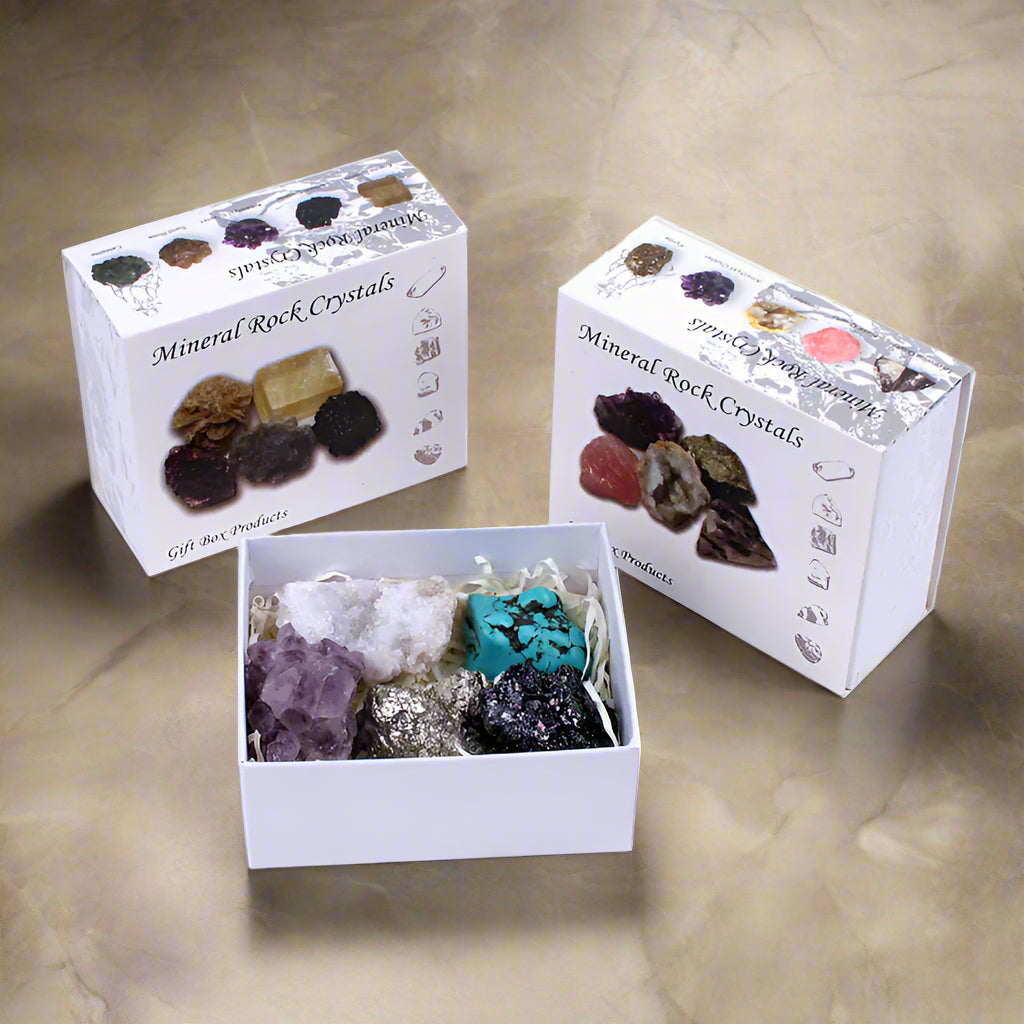 Three boxes of mineral rock crystals on a white background