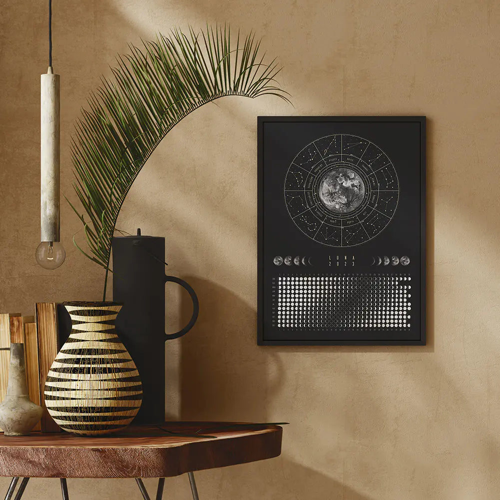 Decorative setup with a mirror, vase, and framed artwork on a beige wall.