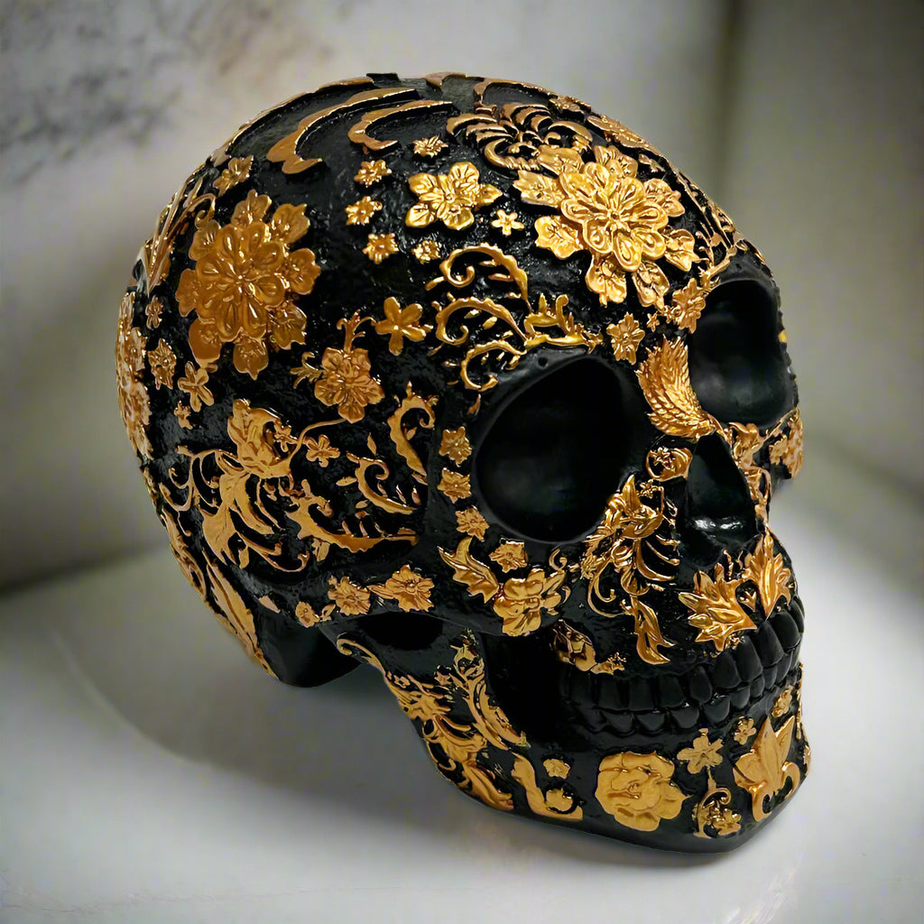 Decorative skull with gold floral patterns on a white background