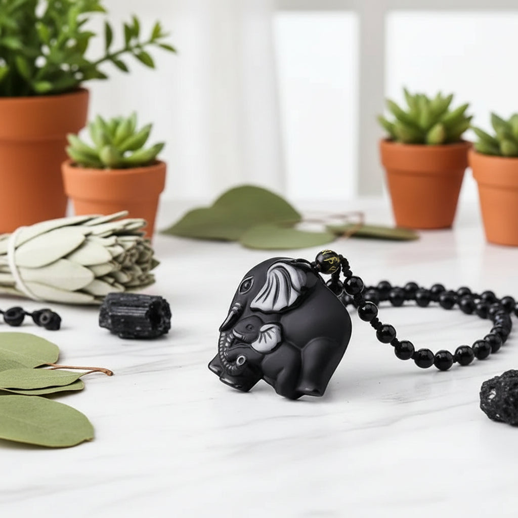 Black elephant pendant with white details on a blurred floral background