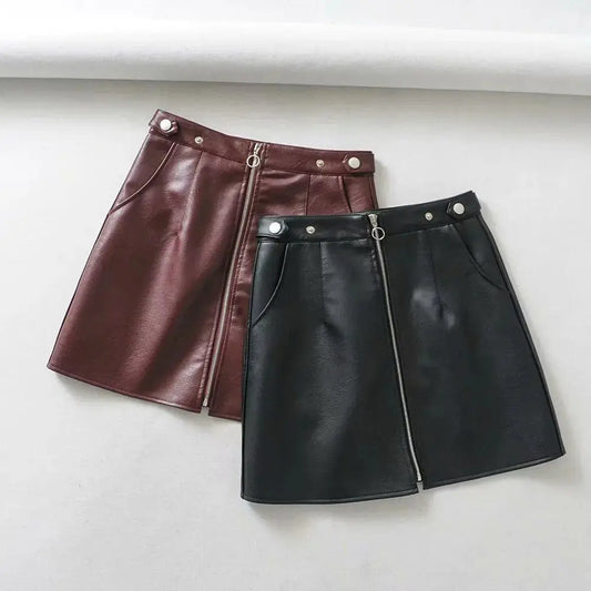 Two leather skirts, one brown and one black, on a light gray background.