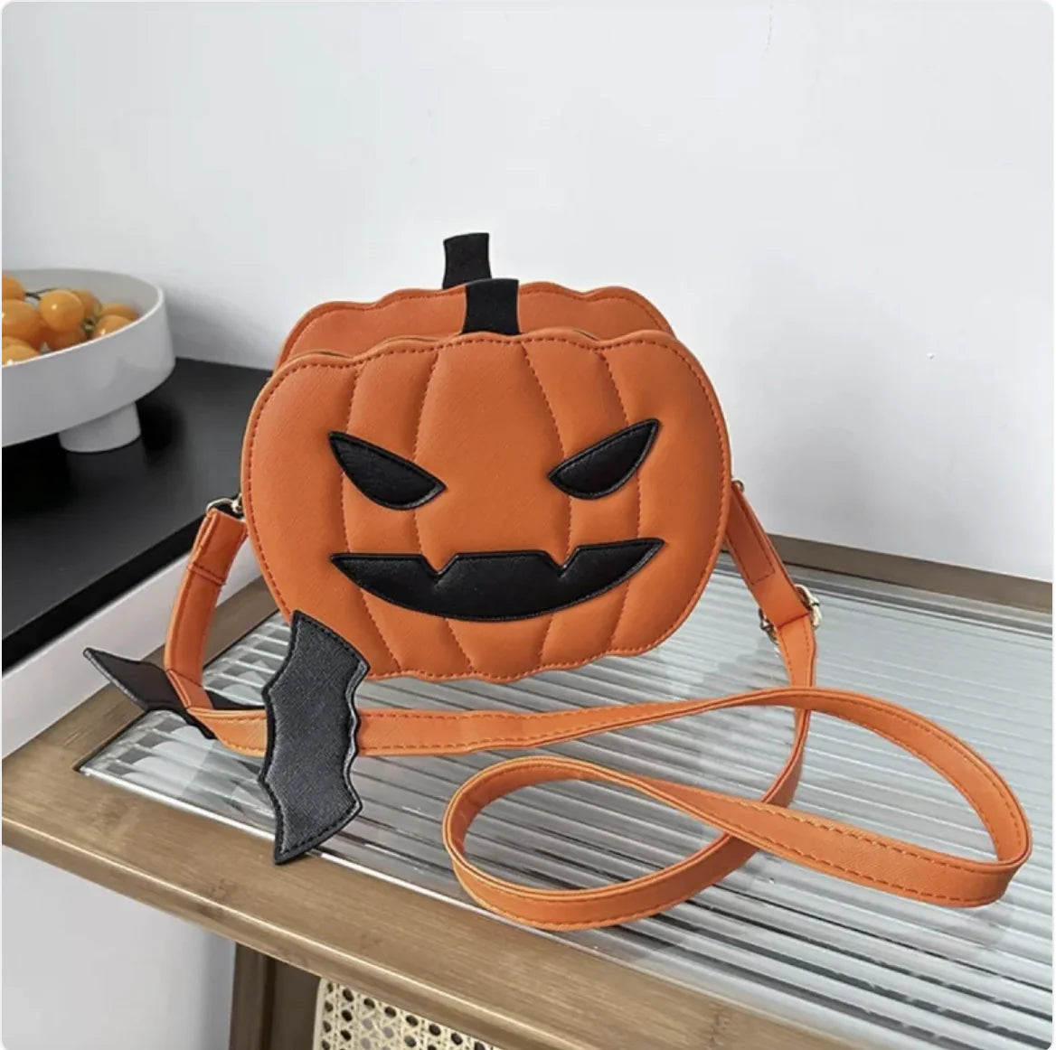 Pumpkin-shaped bag with a bat wing on a table
