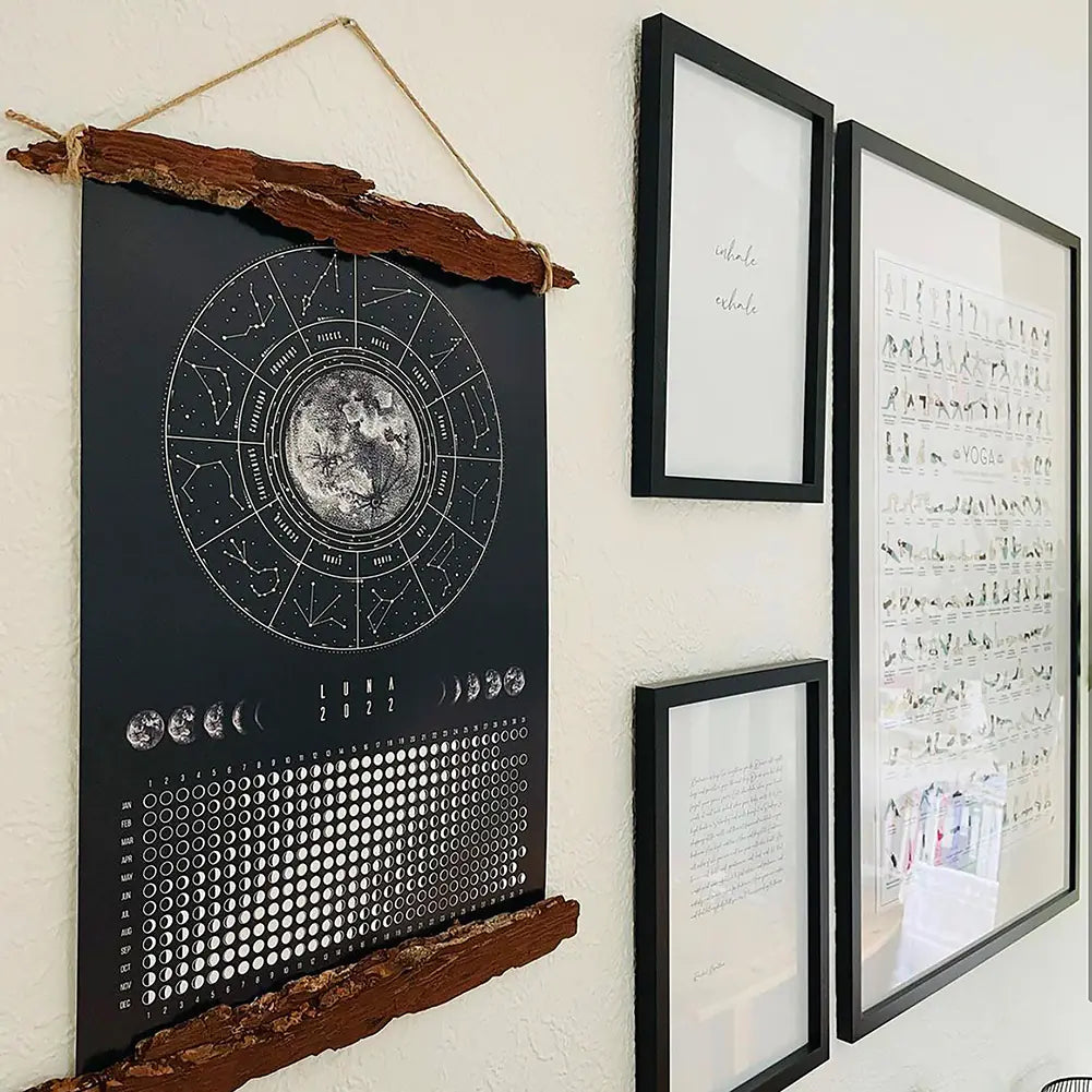 Decorative wall art with celestial design and framed text on a white wall.