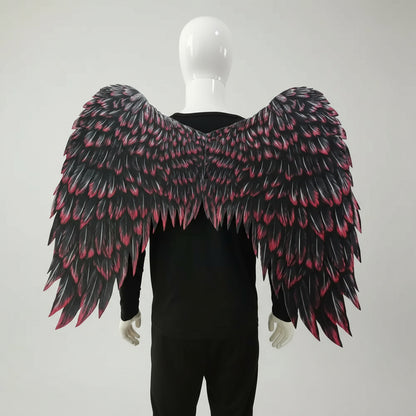Black and pink feathered wings on a mannequin against a white background