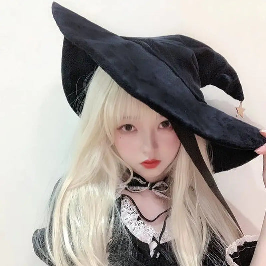 Person wearing a black witch hat with a plain background