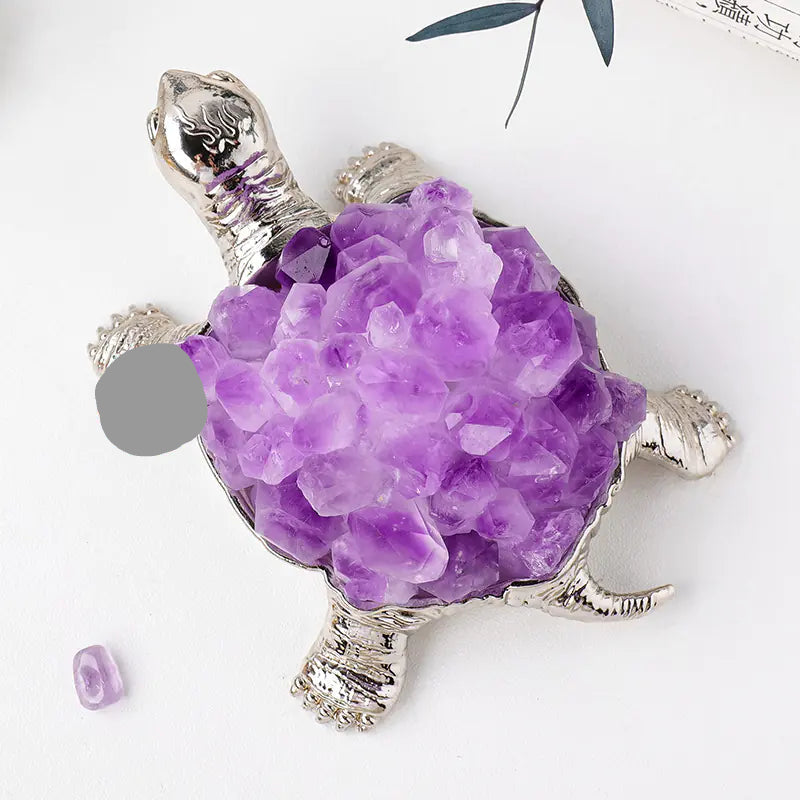 Tortoise-shaped object with purple crystal-like material on a white background