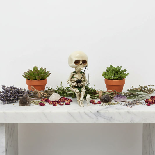 Skeletal figure with fishing rod and fish on a white background