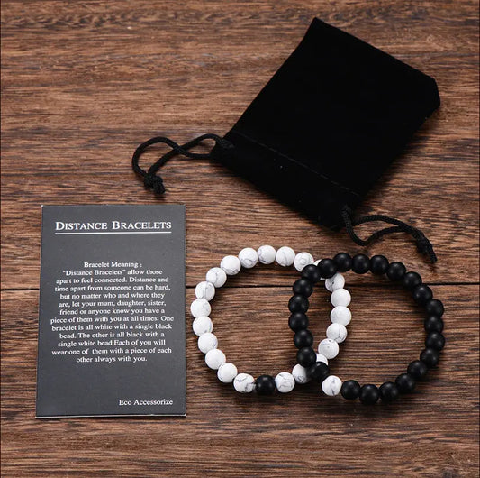 Black and white beaded bracelets with a card on a wooden surface