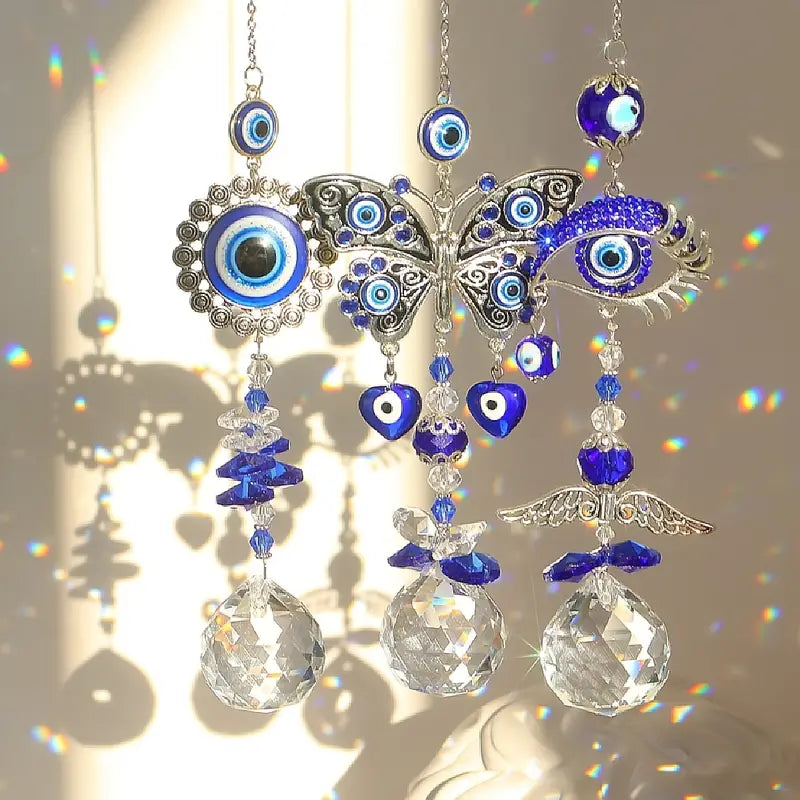 Decorative hanging ornament with blue evil eye designs and crystal balls on a reflective surface.