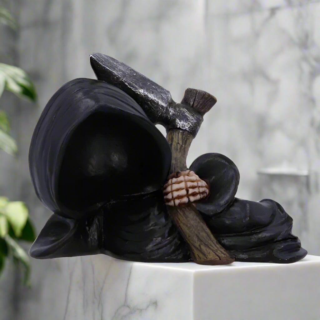 Grim Reaper figurine holding a scythe on a white background