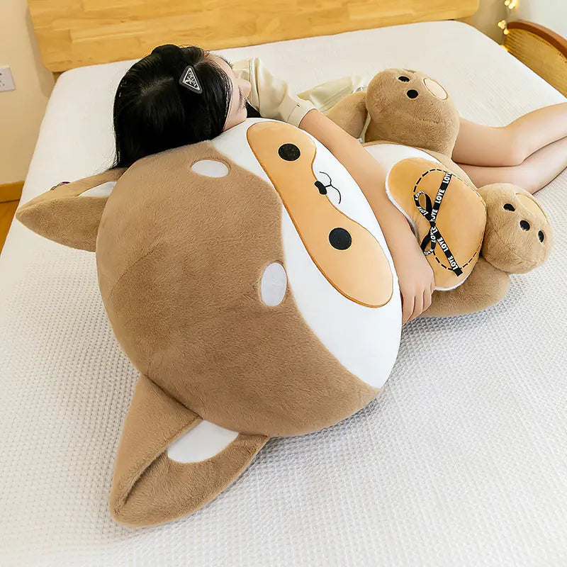 Person lying on a large plush shark toy on a bed