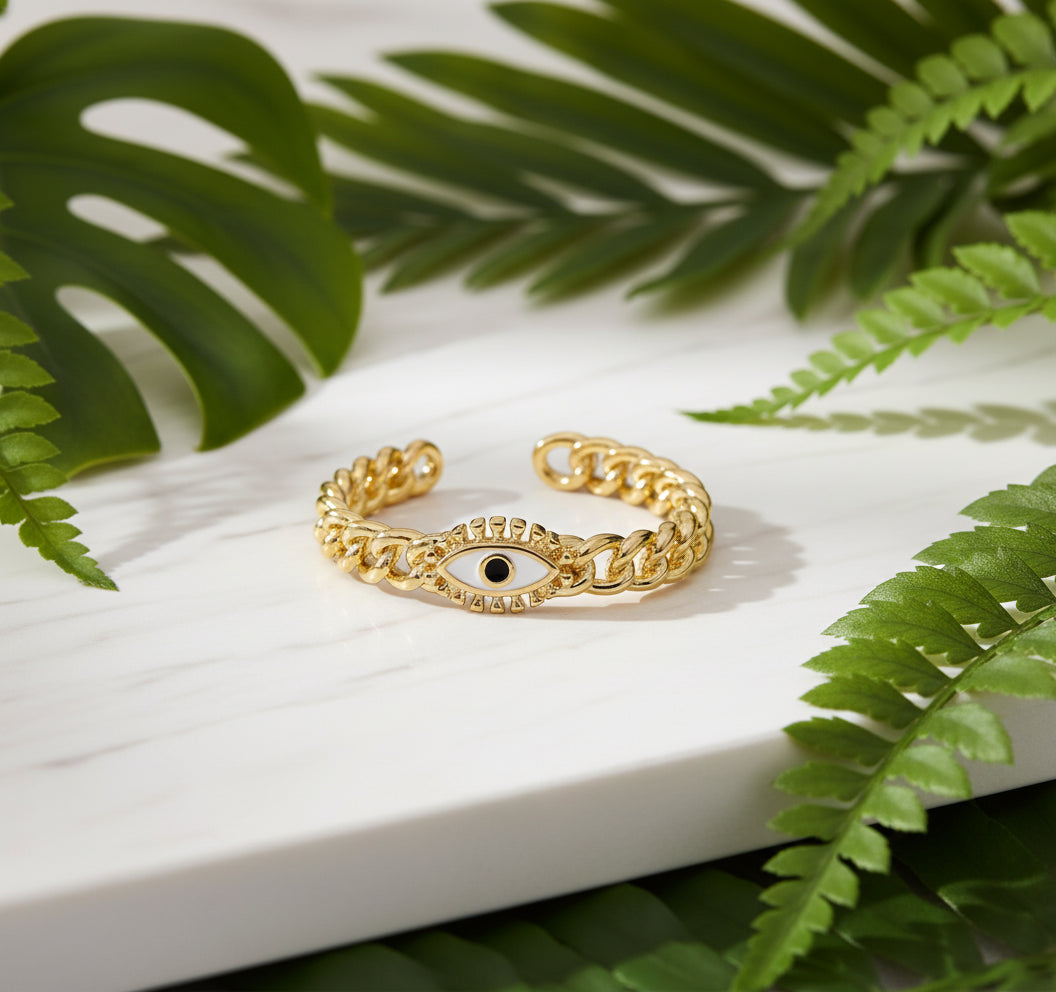 Gold chain ring with a black stone on a white background