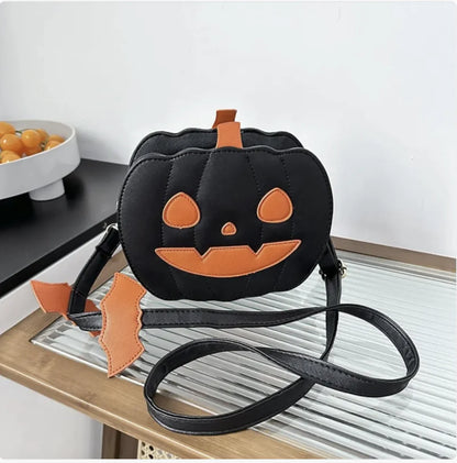 Black pumpkin-shaped bag with orange accents on a white surface