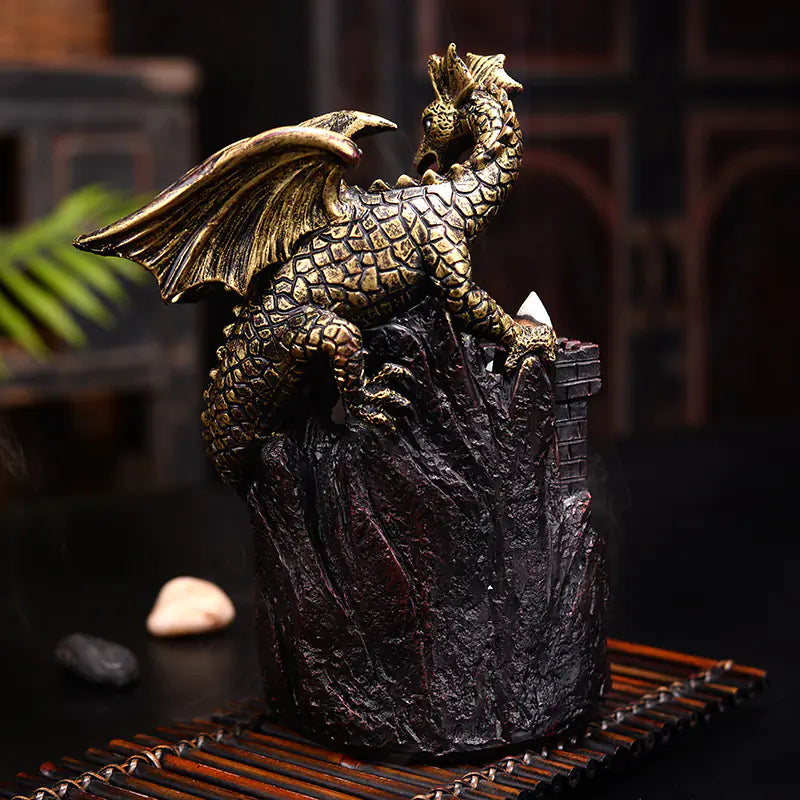 Bronze dragon sculpture on a rocky base with a blurred background