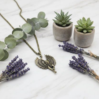 Bronze winged cat pendant on a chain against a stone background